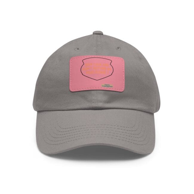 Close-up of a gray baseball cap with a pink patch on the front, showing stitching and a small top button.