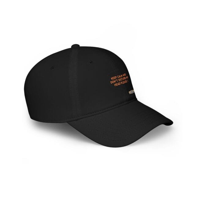 Close-up of a black baseball cap with orange text printed on the side: 'KEEP CALM AND DON DISTURB MY HEAD PLEASE!'