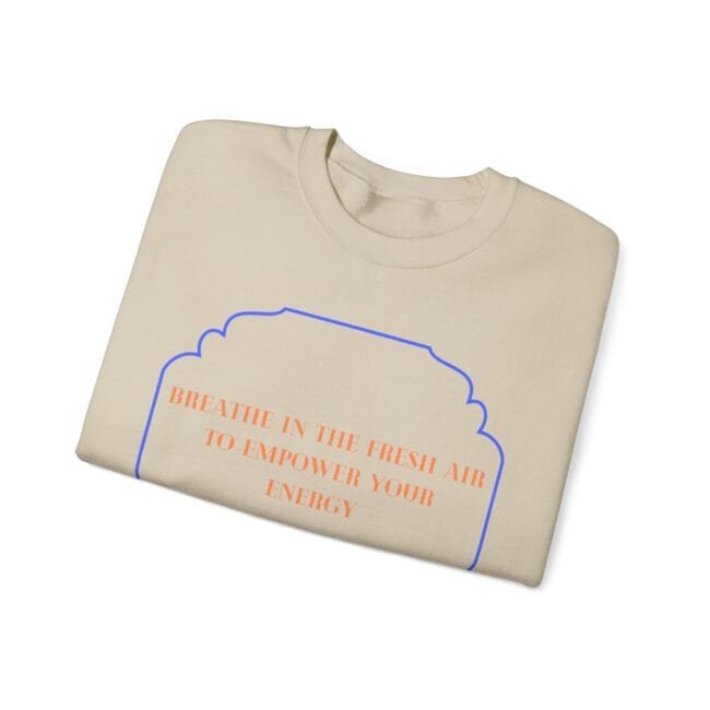 Beige sweatshirt showing a blue arched outline and orange text: 'BREATHE IN THE FRESH AIR TO EMPOWER YOUR ENERGY' across the chest area (product image).