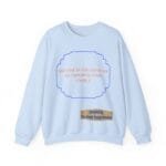 Light blue sweatshirt with an orange quote inside a blue scalloped frame: 'BREATHE IN THE FRESH AIR TO EMPOWER YOUR ENERGY', plus a beige designer label 'Designed By The Simple Design MindSet'.