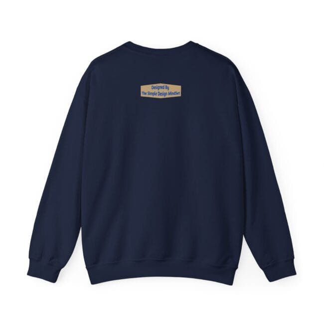 Navy sweatshirt shown from the back with a small tan label on the upper center that reads 'Designed By The Simple Design Mindset'
