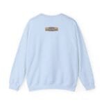 Light blue sweatshirt seen from the back with a small beige label on the upper back reading: Designed By The Simple Design Mindset