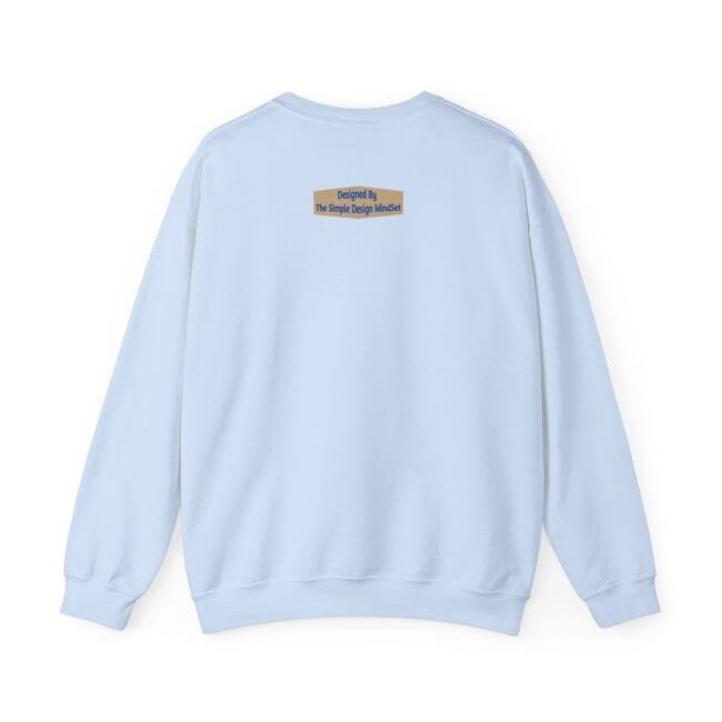 Light blue sweatshirt seen from the back with a small beige label on the upper back reading: Designed By The Simple Design Mindset