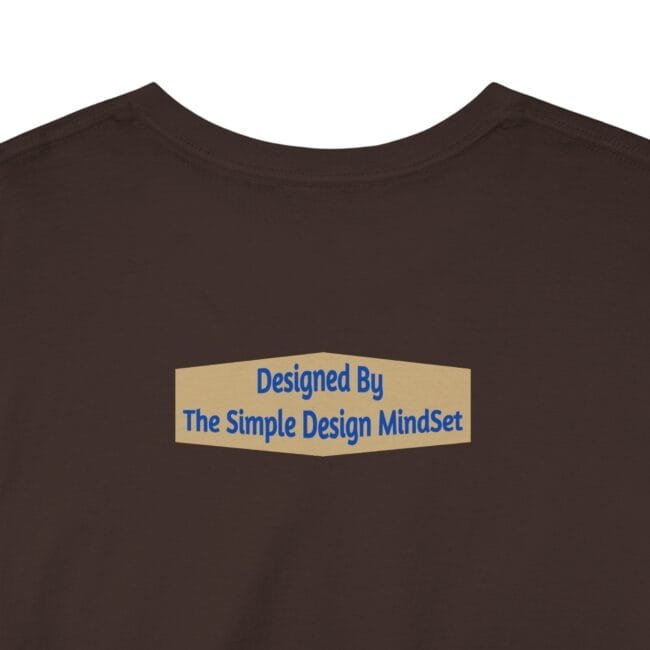 Brown t-shirt back displays a beige badge with the text: “Designed By The Simple Design MindSet.”