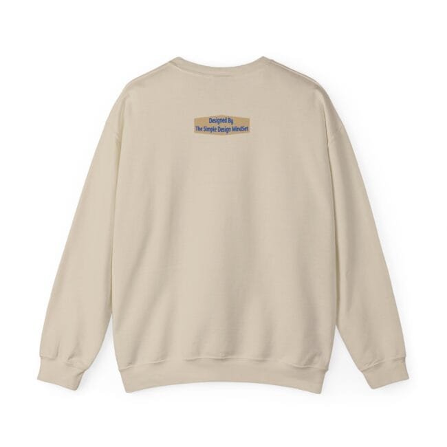 Beige crewneck sweatshirt shown from the back with a small tan label on the upper back reading 'Designed By The Simple Design Mindset'.