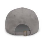 Close-up of a gray baseball cap showing the crown, panels, and an adjustable back strap with a brass buckle from a top-front angle