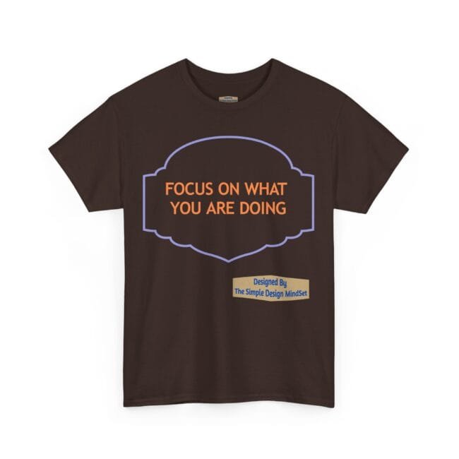 Brown T-shirt featuring a purple decorative badge outline with orange text: 'FOCUS ON WHAT YOU ARE DOING'.