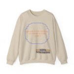 Beige sweatshirt with orange text inside a blue decorative frame: 'BREATHE IN THE FRESH AIR TO EMPOWER YOUR ENERGY'; designer label below.