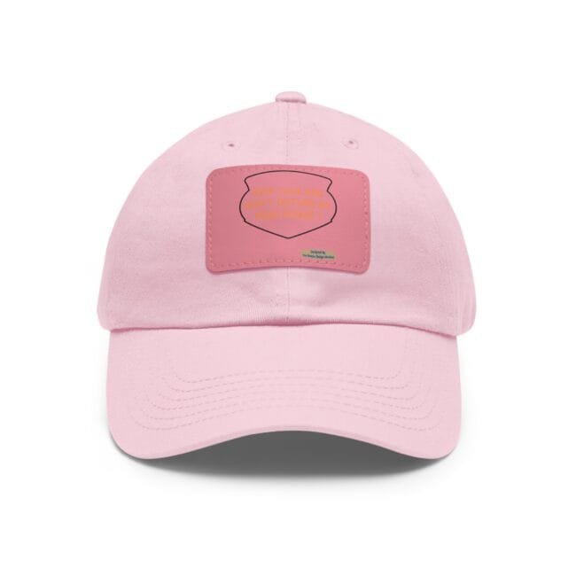 Close-up of a pink baseball cap facing upward, showing a stitched front patch on the cap's surface.