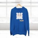 Blue hoodie on a wooden hanger with a white decorative label and a small designer tag showing at the chest area.