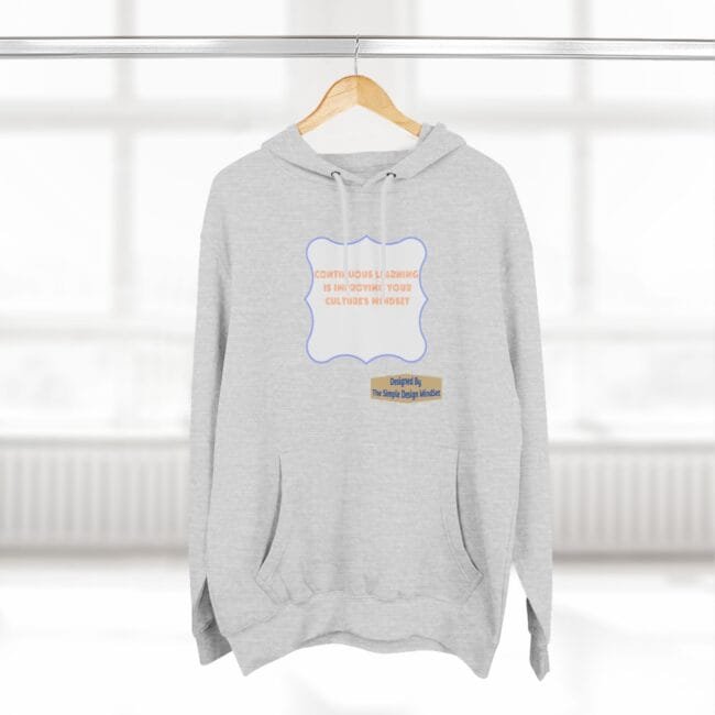 Gray hoodie on a hanger with a blue-framed orange text slogan: 'Continuous learning is improving your culture's mindset.' with a small designer label.
