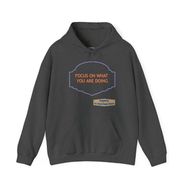 Dark gray hoodie with a purple decorative badge containing the orange slogan 'FOCUS ON WHAT YOU ARE DOING' and a small beige designer tag below.
