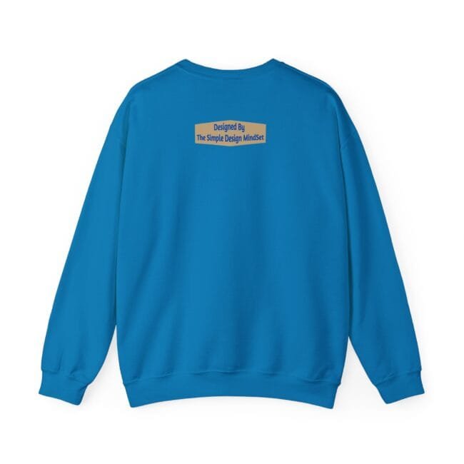 Back view of a blue sweatshirt with a small beige label on the upper back that reads 'Designed By The Simple Design MindSet'