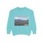 Light blue sweatshirt with a desert landscape print and the phrase “Take a coffee or juice in the desert to resolve the problem.”