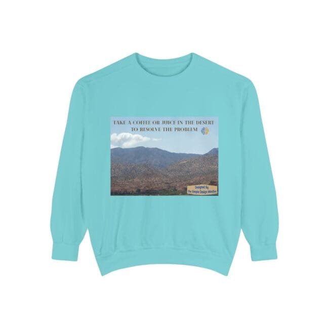 Light blue sweatshirt with a desert landscape print and the phrase “Take a coffee or juice in the desert to resolve the problem.”