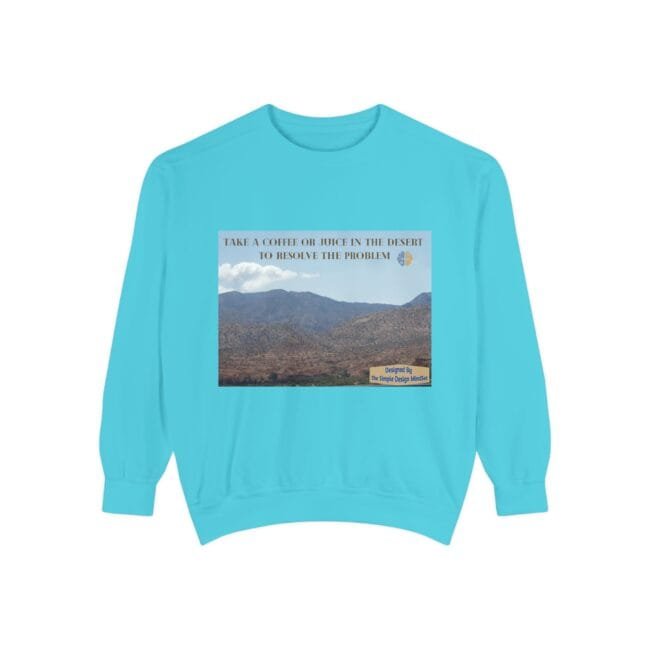 Turquoise sweatshirt with a desert landscape graphic and the words: 'Take a coffee or juice in the desert to resolve the problem' across the top; small label in the bottom-right corner.