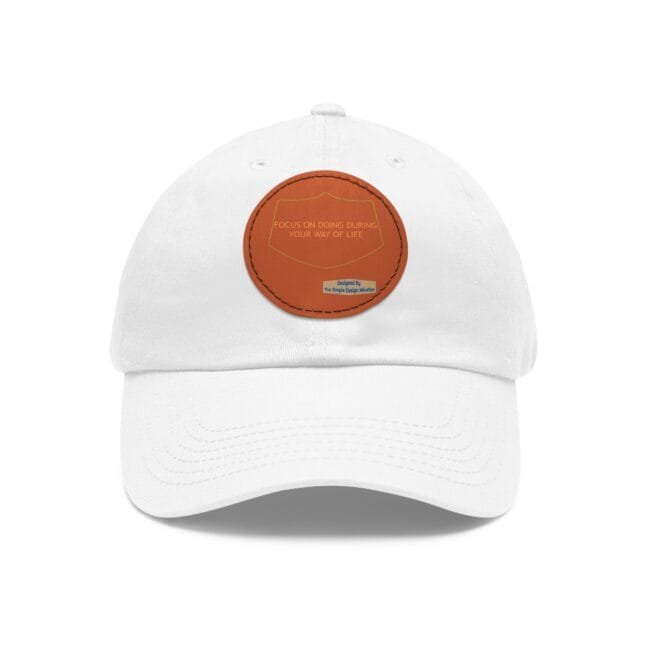 White baseball cap featuring an orange circular patch on the front with the motto: 'Focus on doing during your way of life' and a small blue designer label beneath.