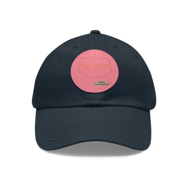 Navy baseball cap with a pink circular patch on the front.