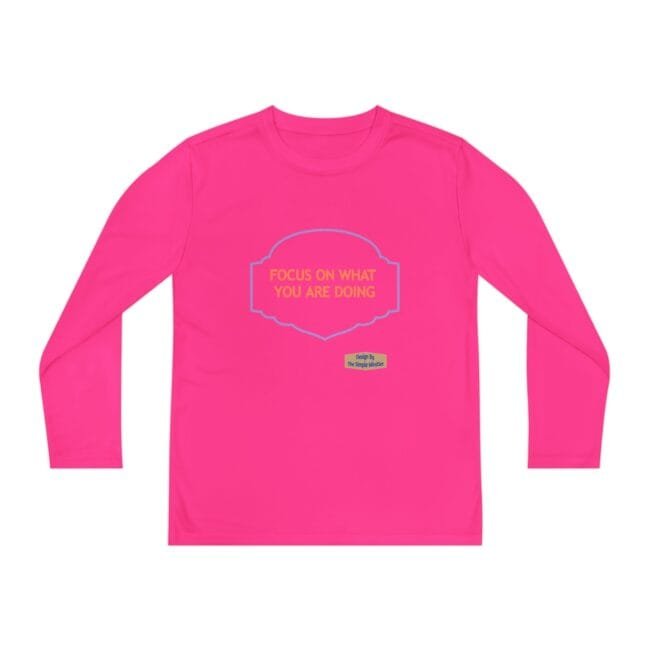 Bright pink long-sleeve shirt with a blue decorative badge and the message 'FOCUS ON WHAT YOU ARE DOING' in orange text.