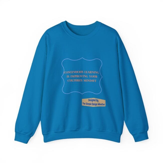 Bright blue sweatshirt with a decorative purple frame and orange text: 'Continuous learning is improving your cultures mindset' plus a small beige label reading 'Designed By The Simple Design MindSet'