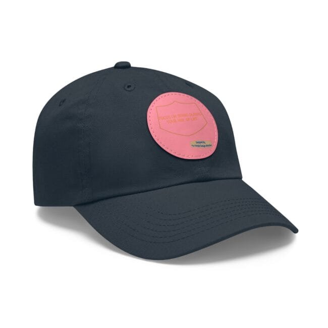 Navy baseball cap with a pink circular patch on the front, visible stitching along the brim.