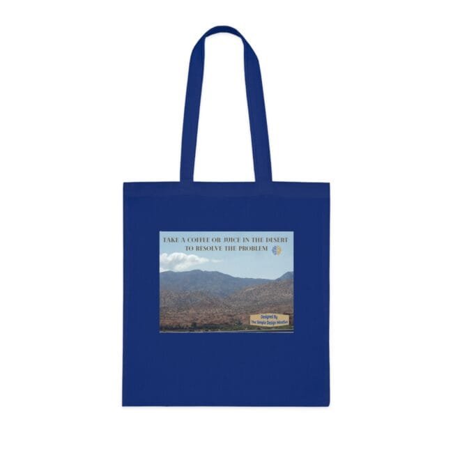 Blue reusable tote bag with a desert landscape print and the slogan 'Take a coffee or juice in the desert to resolve the problem' on the front panel.