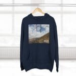 Navy hoodie with a rectangular landscape print of hills and cloudy sky on the chest and the text “Keep calm and increase your concentration.”