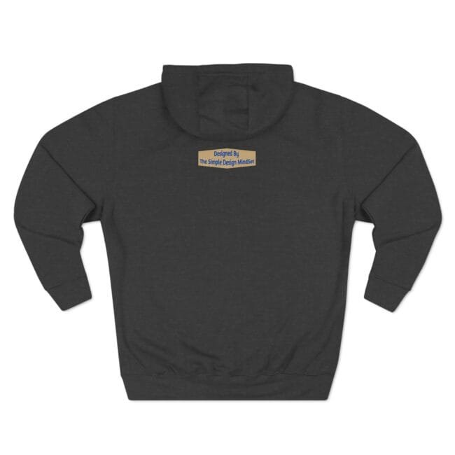 Dark charcoal hoodie with a small tan label on the upper back that reads “Designed By The Simple Design MindSet.”