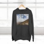 Dark charcoal hoodie on a hanger featuring a rectangular landscape print (hills and blue sky) with the text 'Keep calm and increase your concentration'.