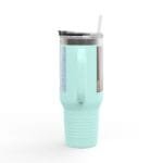 Mint green insulated tumbler with a clear lid and straw, showing side labels/graphics for a product photo.