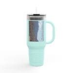 Mint green insulated tumbler with a clear lid and straw, displaying a desert canyon label on its side.