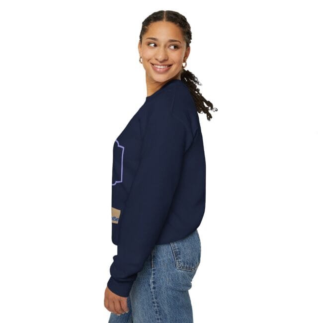 Woman in a navy sweatshirt shown in side profile, smiling while wearing jeans.