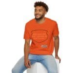 Smiling man in an orange T-shirt sitting on a white block; shirt reads, “KEEP CALM AND DON'T DISTURB MY HEAD PLEASE!”