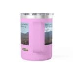 Pink insulated travel mug with a clear lid and a built-in center handle, displaying two desert landscape posters on the sides.