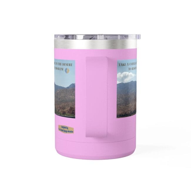 Pink insulated travel mug with a clear lid and a built-in center handle, displaying two desert landscape posters on the sides.