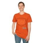 Man in an orange T-shirt smiling, with a shield-shaped graphic that reads: 'KEEP CALM AND DON'T DISTURB MY HEAD PLEASE!'