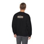 Back view of a person in a black sweatshirt; a small tan label on the upper back reads 'Designed By The Simple Design MindSet'.