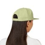 Back view of a person with long dark hair wearing a light lime-green baseball cap, adjustable strap visible at the back.