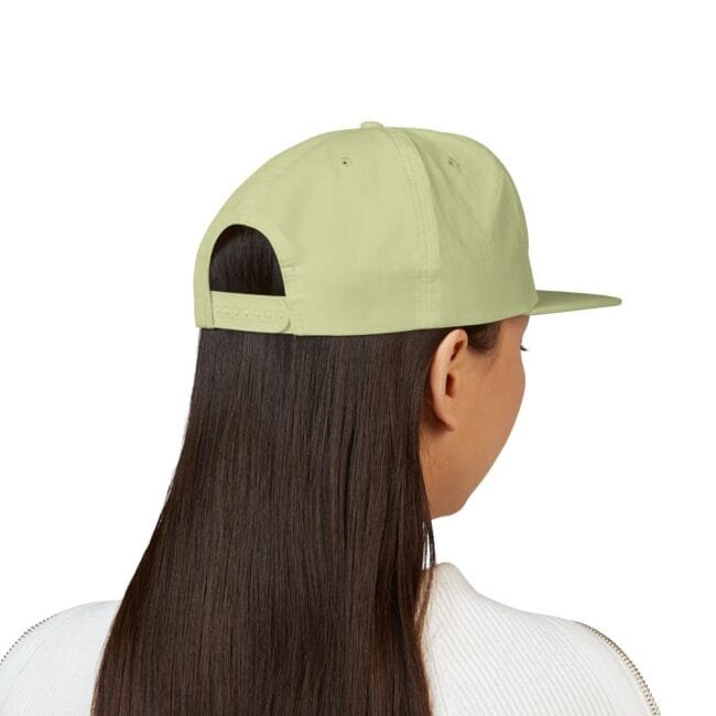 Back view of a person with long dark hair wearing a light lime-green baseball cap, adjustable strap visible at the back.