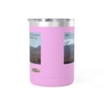 Pink cylindrical tumbler with a clear lid and landscape posters on its sides, featuring desert mountains.