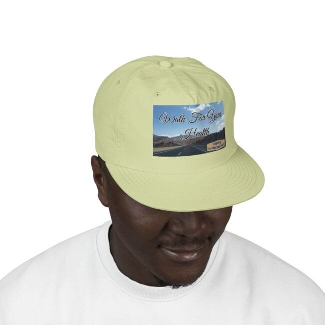 Light yellow cap with a 'Walk For Your Health' graphic patch on the front, worn by a person in a white shirt.