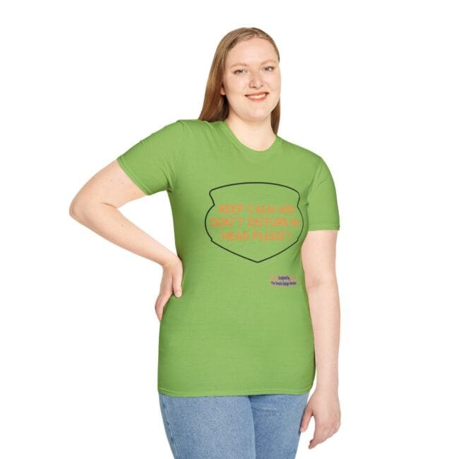 Woman smiling and wearing a lime-green T-shirt with an orange slogan inside a shield: 'KEEP CALM AND DON'T DISTURB MY HEAD PLEASE!'