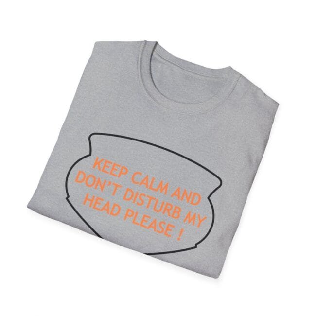 Light gray folded T-shirt with orange text 'KEEP CALM AND DON'T DISTURB MY HEAD PLEASE!' inside a speech bubble outline.