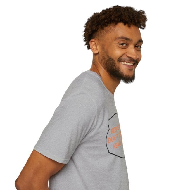 Smiling man in a light gray T‑shirt, turned slightly to the side, posing against a white background.