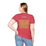 Back view of a woman wearing a red t-shirt with a gold, embossed slogan on the back: 'A PRINCESS IS A GIRL OR A WOMAN WHO CONSERVES HER ETHICS'.
