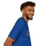 Smiling man wearing a royal blue T-shirt, photographed from the side in a product-shot pose.