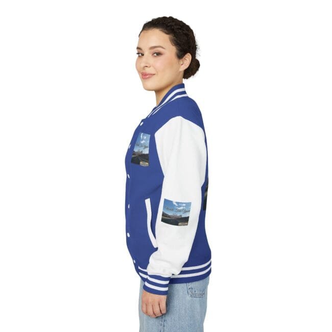 Side view of a woman wearing a blue and white varsity jacket with patches on the sleeves and chest, smiling slightly