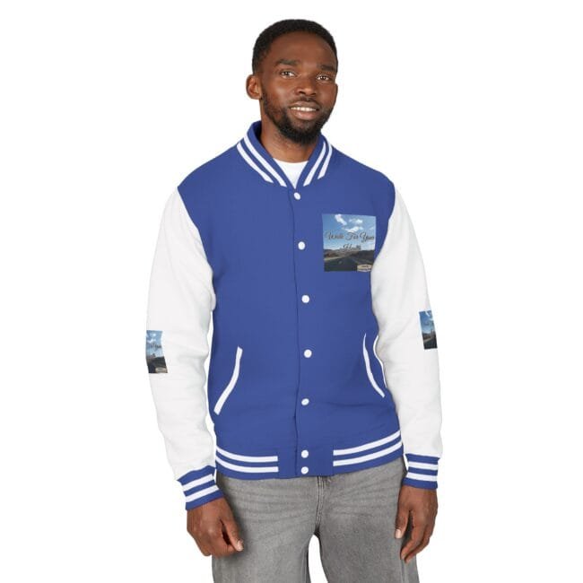 Man wearing a blue and white varsity jacket with striped cuffs and collar, standing against a white background.