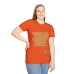 Woman wearing an orange t-shirt with the slogan: 'A princess is a girl or a woman who conserves her ethics', standing with one hand on hip.