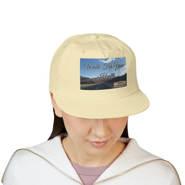 Beige baseball cap with a front graphic that says 'Walk For Your Health' over a landscape image of a road and mountains.